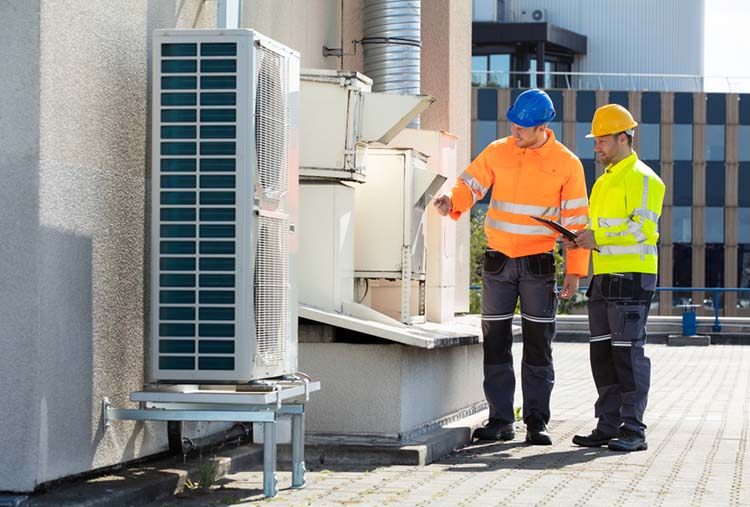 Two,Electricians,Men,Wearing,Safety,Jackets,Checking,Air,Conditioning,Unit